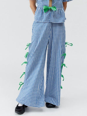Blue gingham wide-leg trousers with green bow details down the sides.