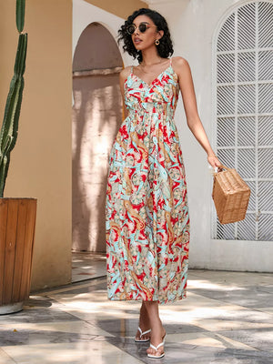 Chic floral midi dress with spaghetti straps and smocked waist in red and blue paisley pattern.