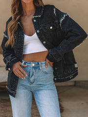 Black washed denim trucker jacket with raw hem and button closure.