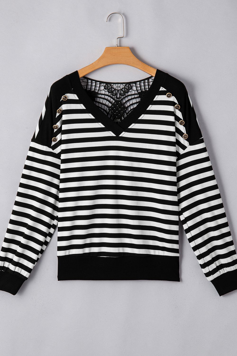 Black and white striped blouse with lace back detail and button accents.
