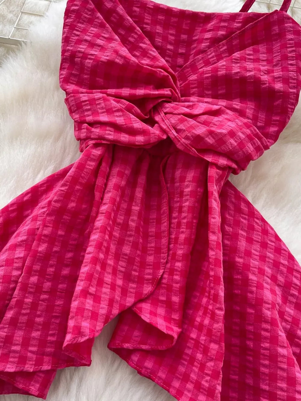 Rose red asymmetrical cami top with a twisted knot detail and gingham pattern.