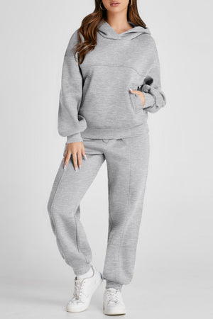 Gray relaxed fit lounge set with seam detail, hoodie with front pocket, and joggers.