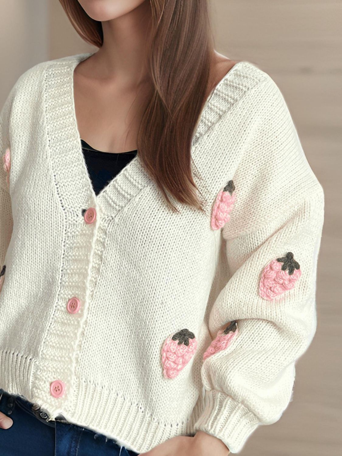 Cream knit cardigan with pink strawberry appliqué and buttons