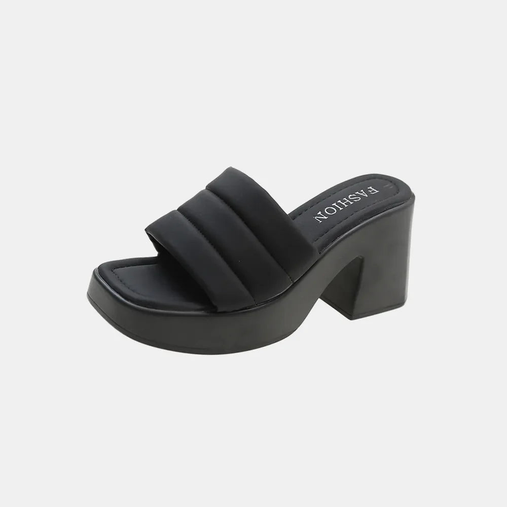 Black padded platform mules with a chunky block heel and square toe.