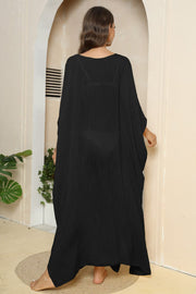 Black oversized caftan cover-up with side slits and textured fabric.