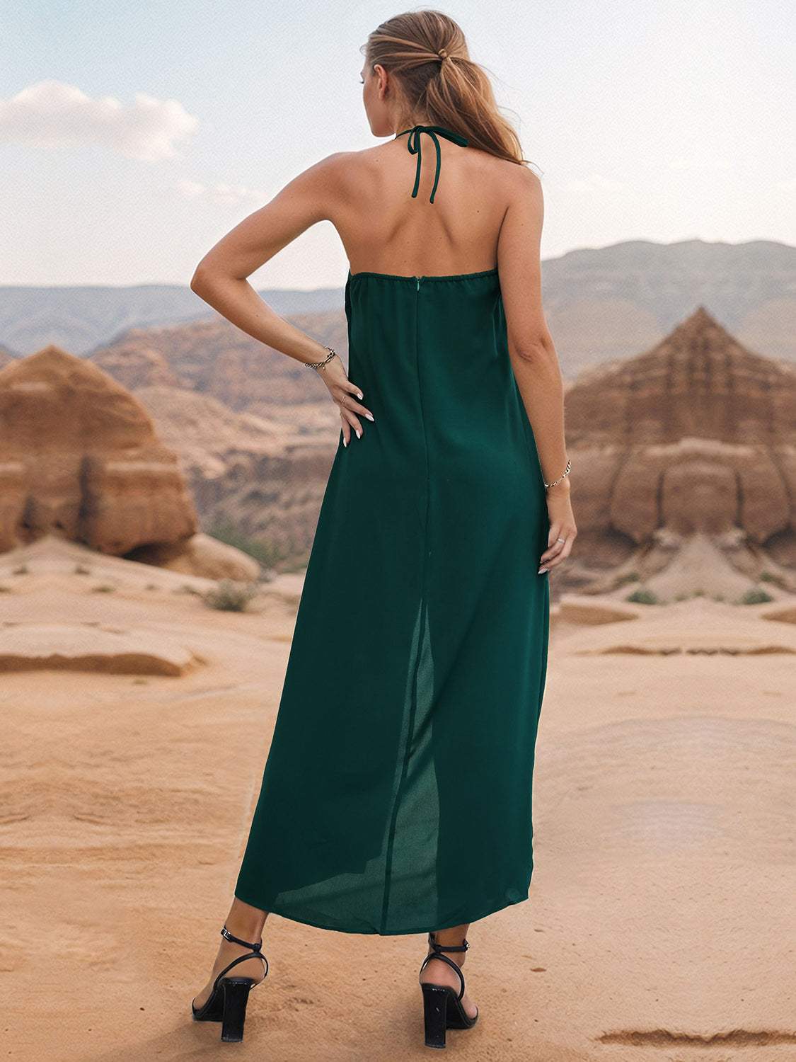 Dark green draped halter jumpsuit with palazzo legs and a back zipper detail.