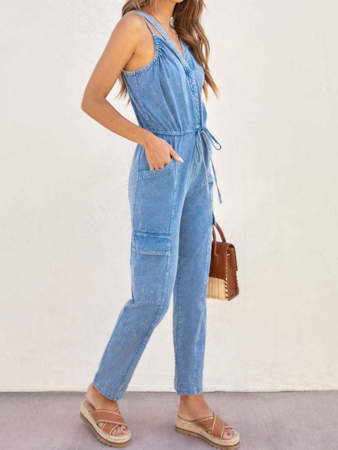 Acid wash cargo jumpsuit in medium with drawstring waist and utility pockets.