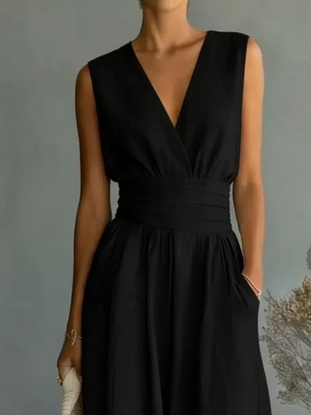 Black sleeveless wide-leg jumpsuit with V-neck, cinched waist, and pockets.