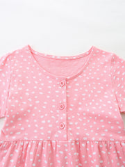 Baby dress in blush pink cotton with white polka dots, button front, and ruffled hem.