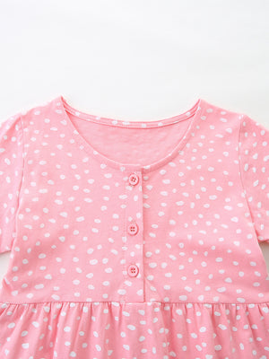 Baby dress in blush pink cotton with white polka dots, button front, and ruffled hem.
