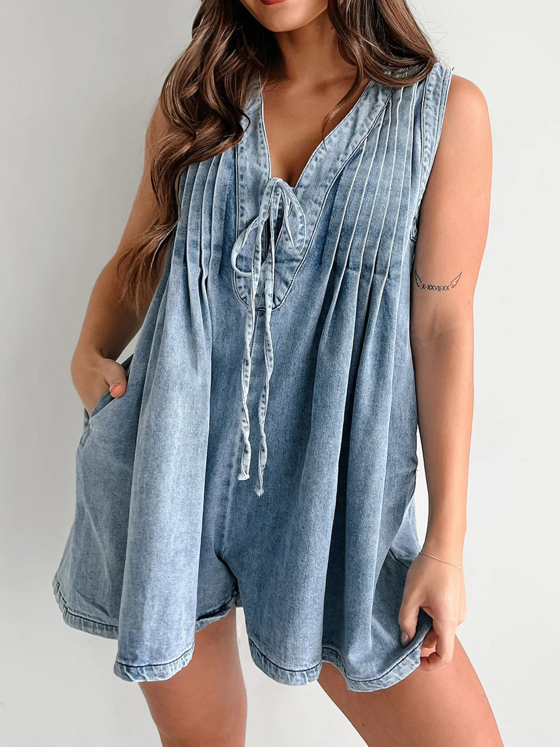 Light blue denim playsuit with tie-front neckline and pleated bodice.