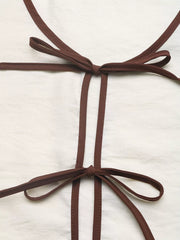Chic tie-front two-piece ensemble in beige with brown trim and bow details.