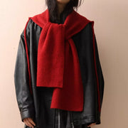 Red knit hooded scarf tied over a black leather jacket.