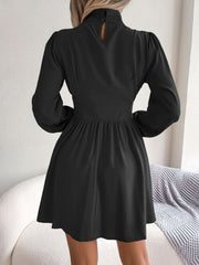 Black fit-and-flare mini dress with keyhole neckline, button detail, and long puff sleeves.