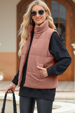Corduroy padded vest in Dusty Pink with funnel neck and zip front, styled with a black sweatshirt.