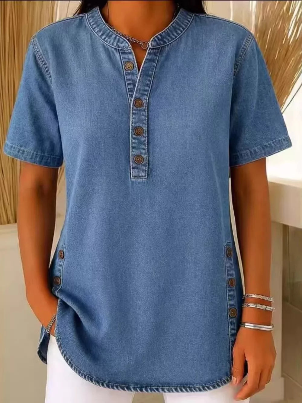 Denim-inspired blue short sleeve button-down blouse with mandarin collar and side button detail.
