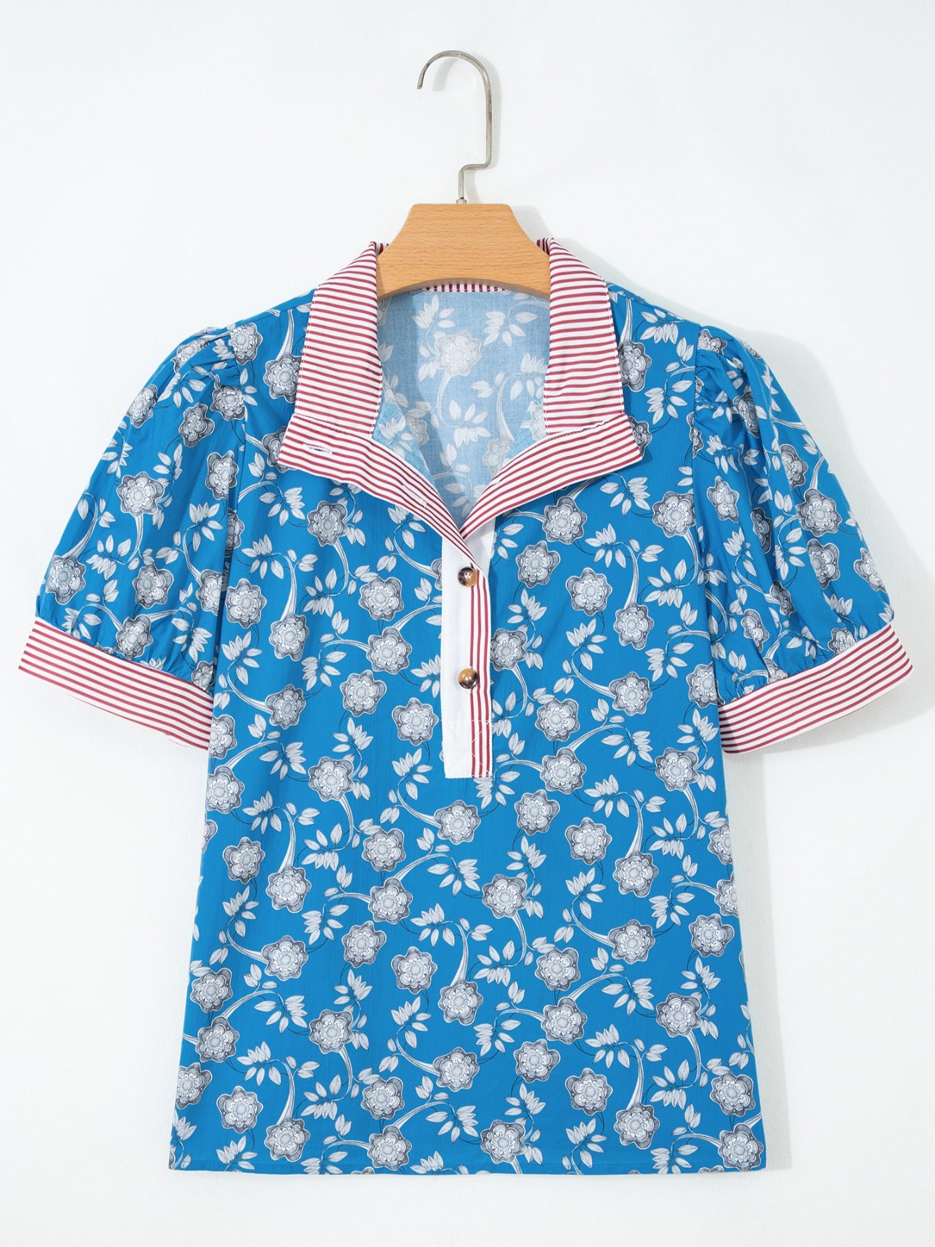 Blue cotton blouse with floral print, puff sleeves, and red striped collar and cuffs.