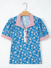 Blue cotton blouse with floral print, puff sleeves, and red striped collar and cuffs.