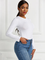 White long sleeve ribbed bodysuit with crew neck, tucked into blue jeans.