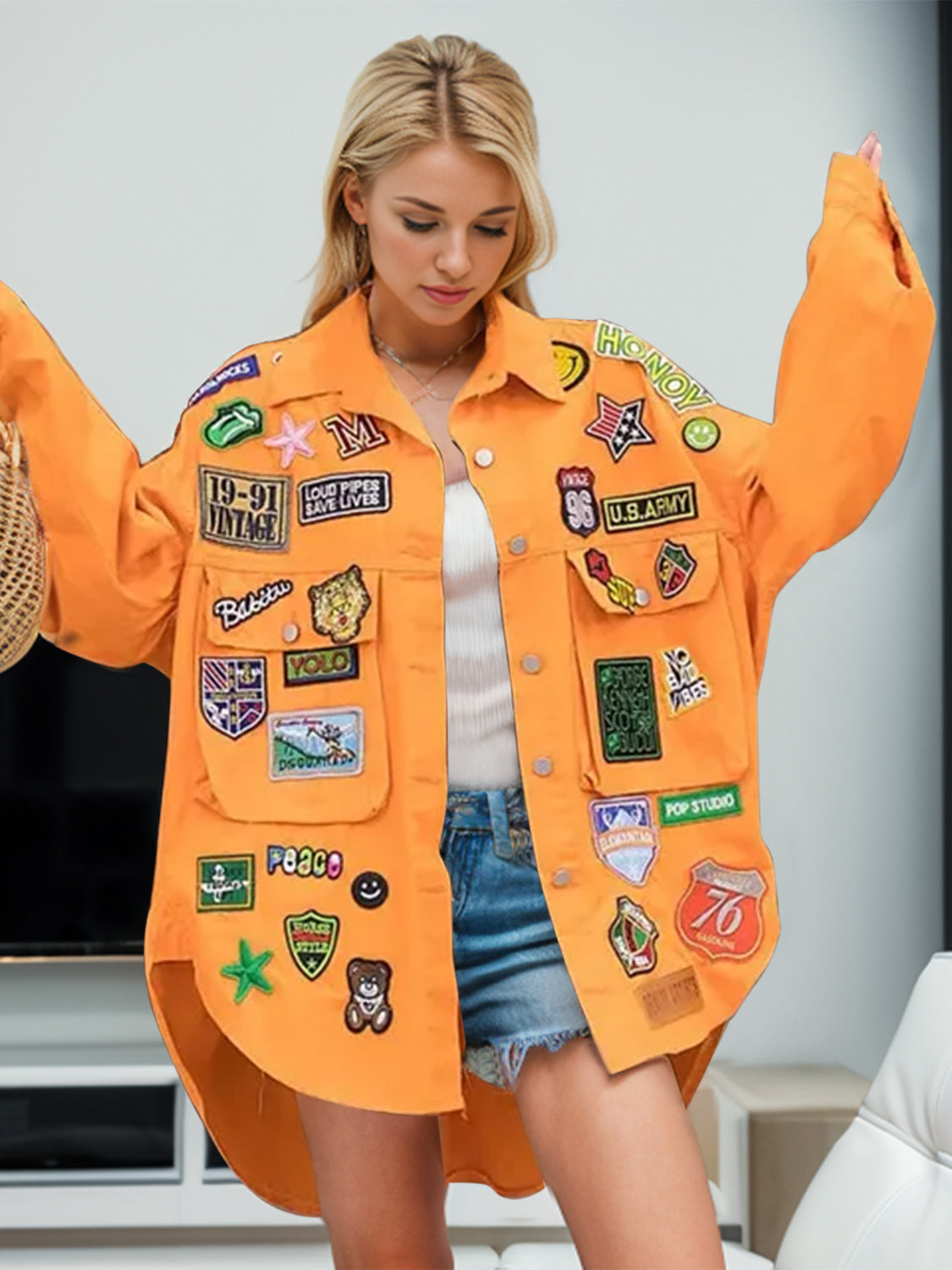 Orange denim trucker jacket with embroidered patches, oversized fit, button front, and chest pockets.