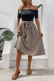 Black off-shoulder midi dress with a patterned A-line skirt and tie waist