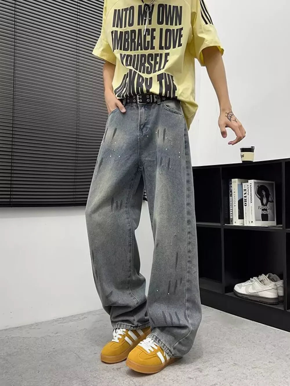 Men's wide-leg denim jeans in grey with paint splatters and distressed details.