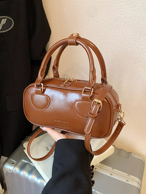 Chic mini crossbody bag in chocolate PU leather with top handles and adjustable strap.
