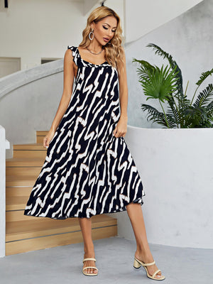 Graphic print tiered midi dress in black and white with ruffle straps and a square neckline.