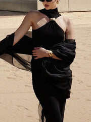 Black asymmetrical halter neck tank top with gold ring detail and sheer draped sleeves.