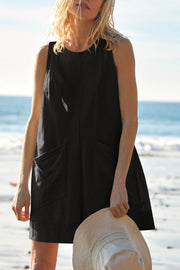 Black linen romper with pockets and a round neckline.