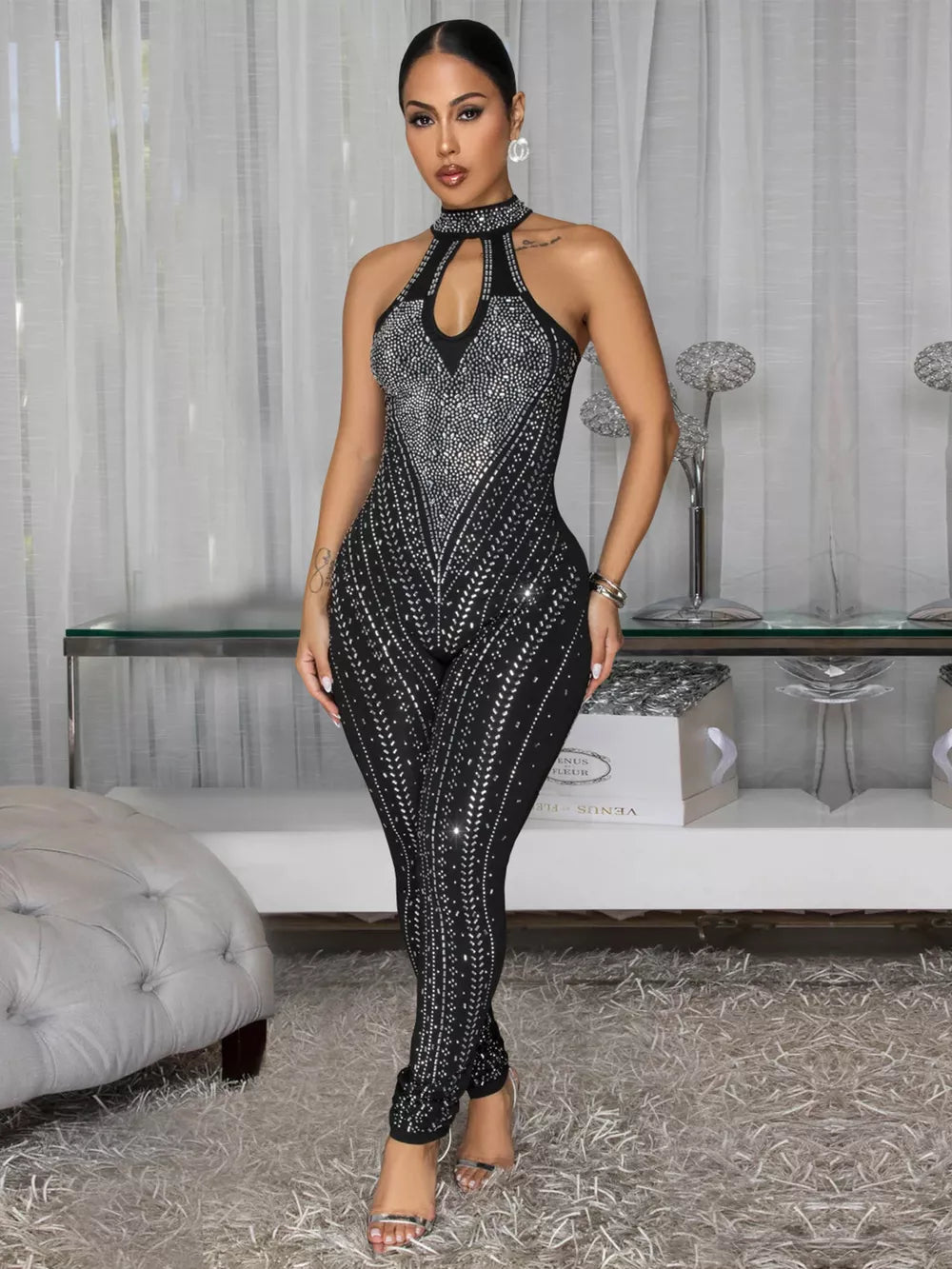Black halter neck romper with rhinestone embellishments and keyhole cutout.