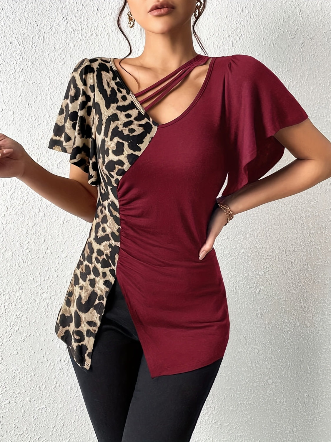 Burgundy asymmetrical top with leopard print panel, ruched side, and strappy neckline.