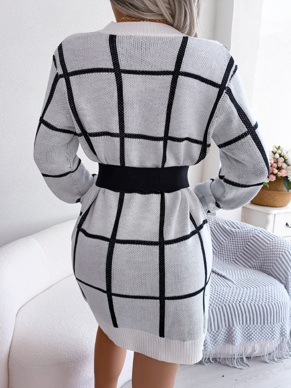 White geometric grid knit mini dress with black grid pattern and black elastic belt.