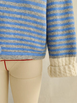 Blue and gray striped knit cardigan with textured cream cuffs.
