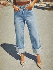 Light wash denim jeans with wide legs and cuffed hems.