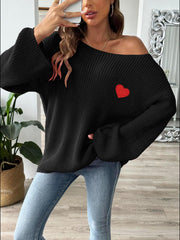 Black slouchy boatneck knit sweater with embroidered red heart detail and bell sleeves.