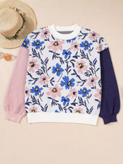 Patchwork floral sweater with pink and navy sleeves, crew neck, and white cuffs.
