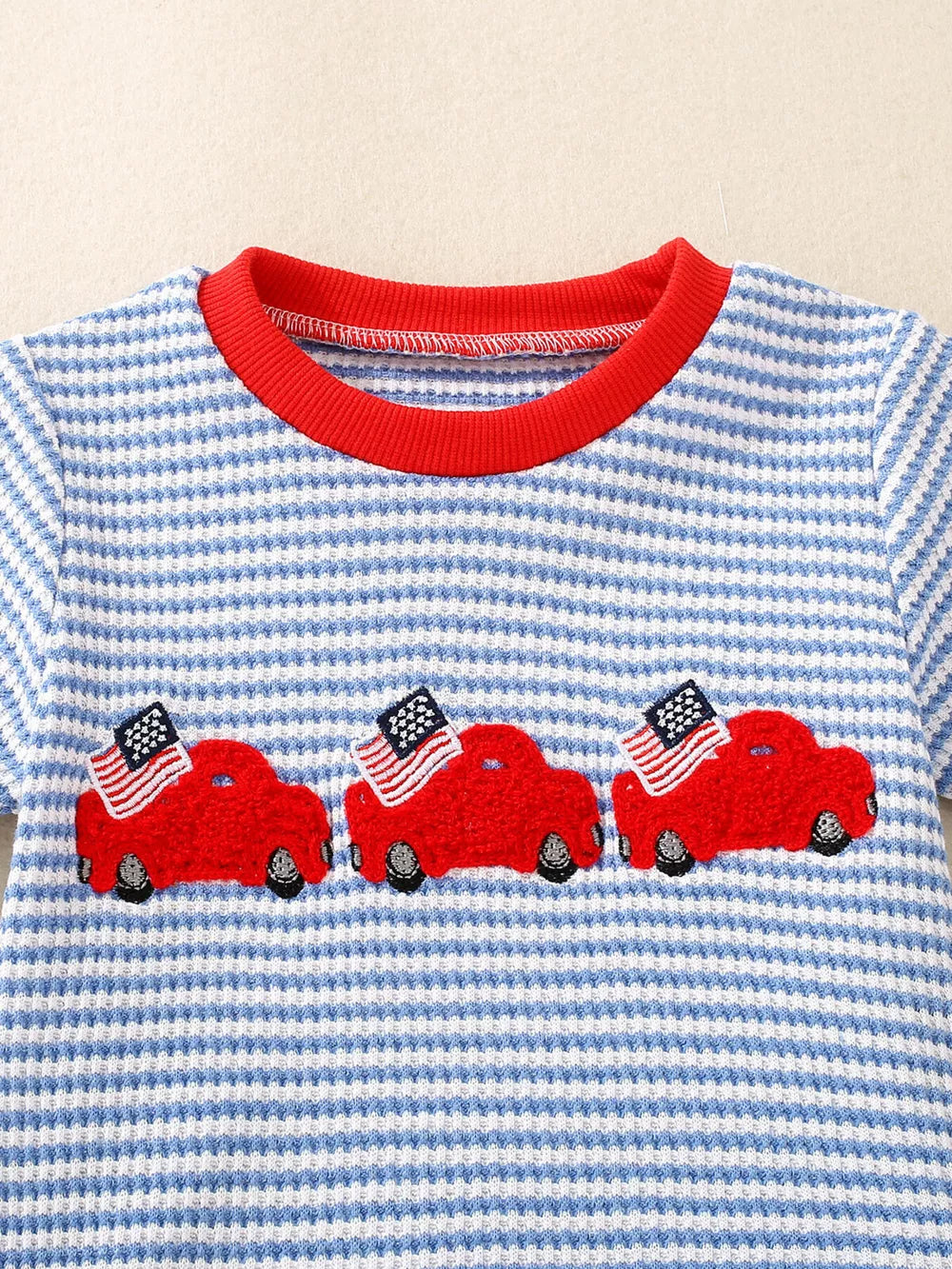 Baby tee with blue and white stripes, red collar, and embroidered red cars with American flags.