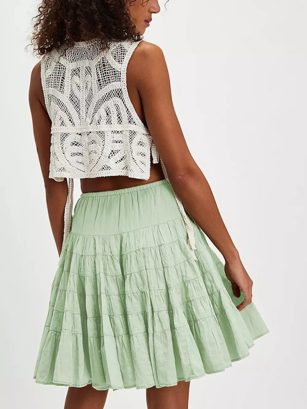 Tiered drawstring mini skirt in Sage green with ruffled tiers and a white crochet crop top.