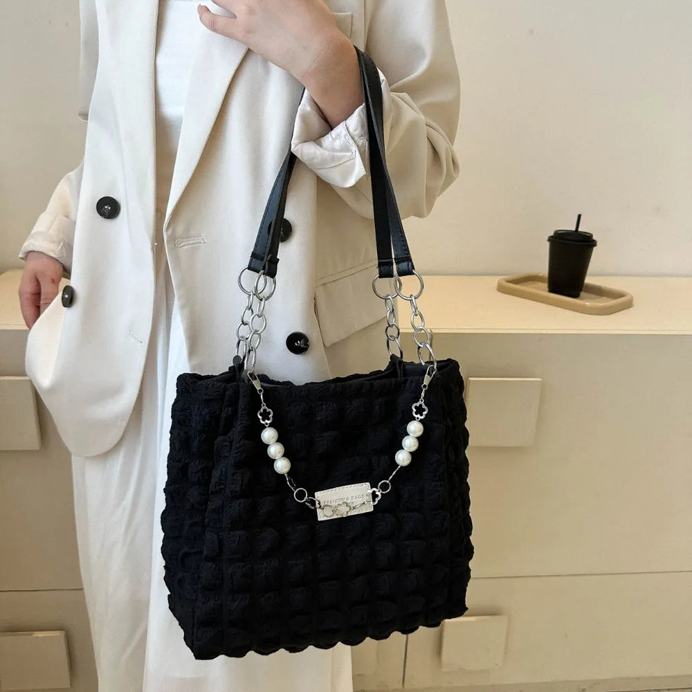 Black textured grid pearl chain tote bag with silver hardware.