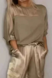Mocha satin two-piece ensemble with crew neck top and cargo pants.