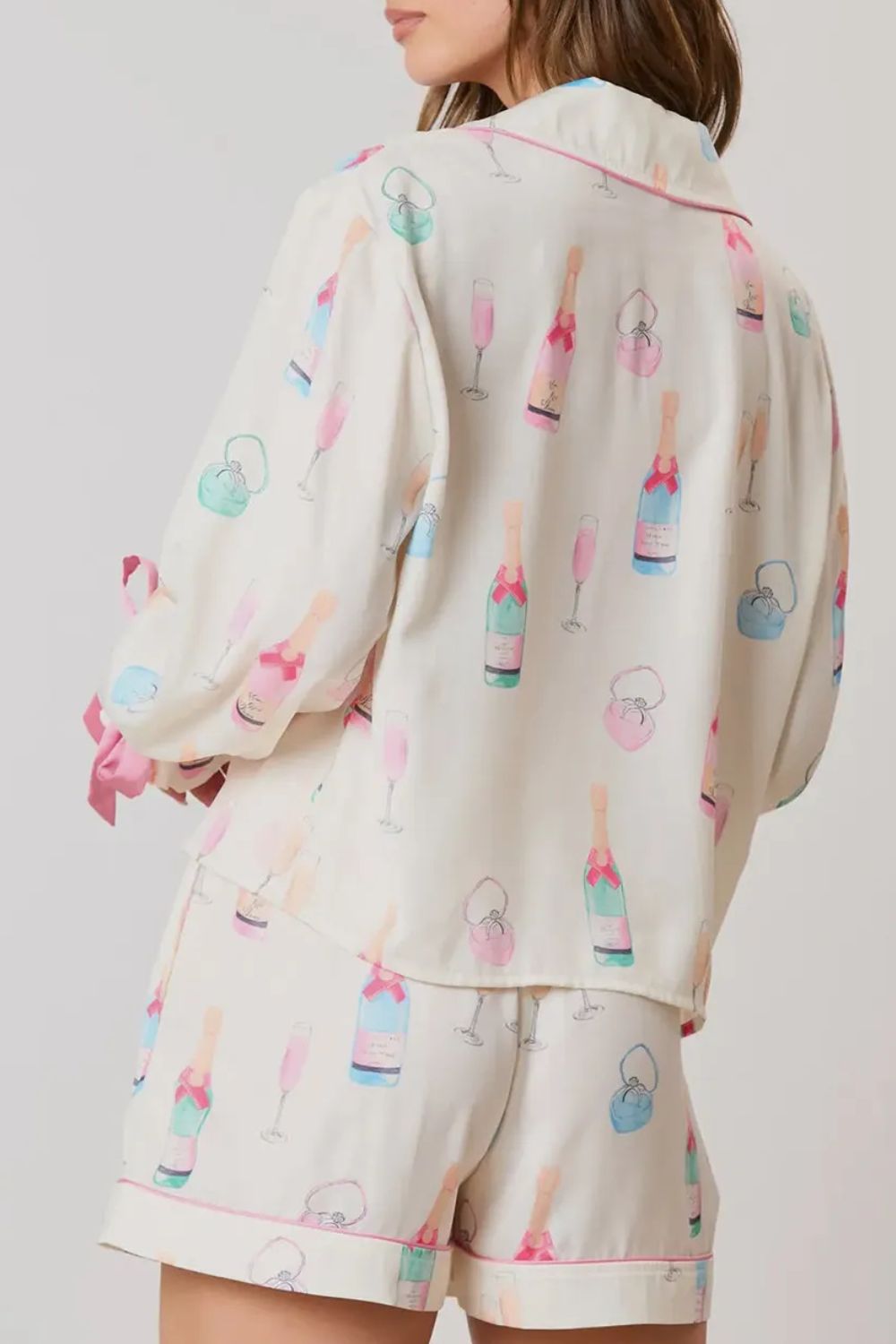 Champagne print silk pajama set in white with bow details and pink trim.