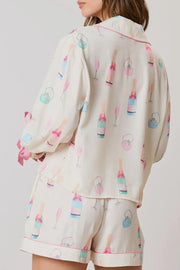 Champagne print silk pajama set in white with bow details and pink trim.