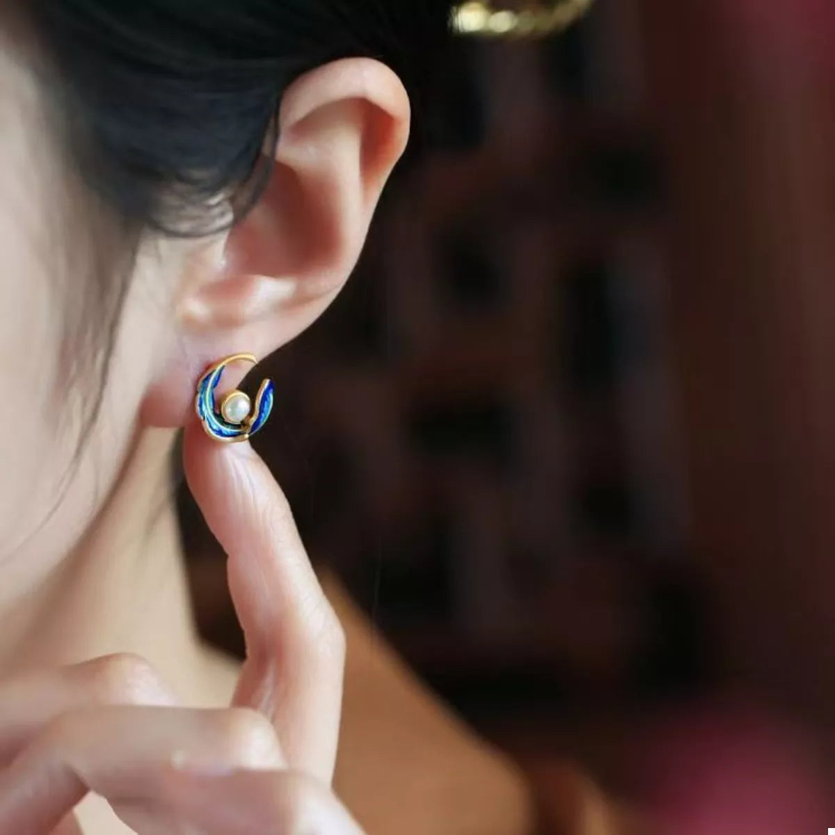 Elegant blue pearl feather earrings with gold accents.