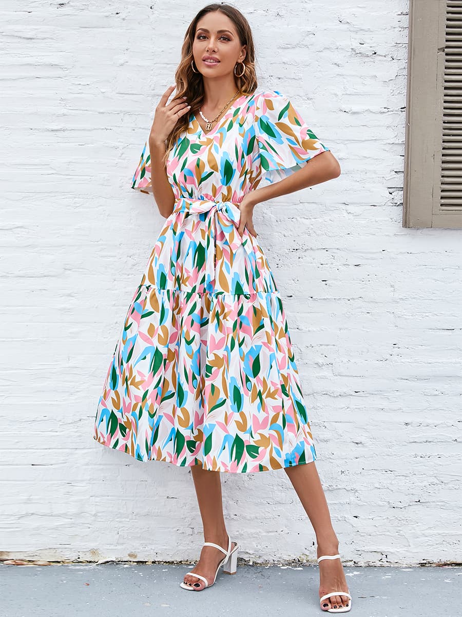 Botanical print midi dress with tie waist, flutter sleeves, and tiered skirt.