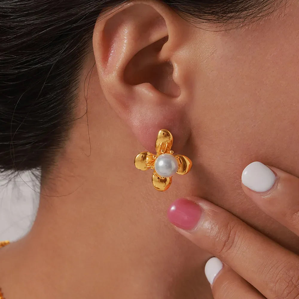 Gold petal pearl stud earrings with a floral design.