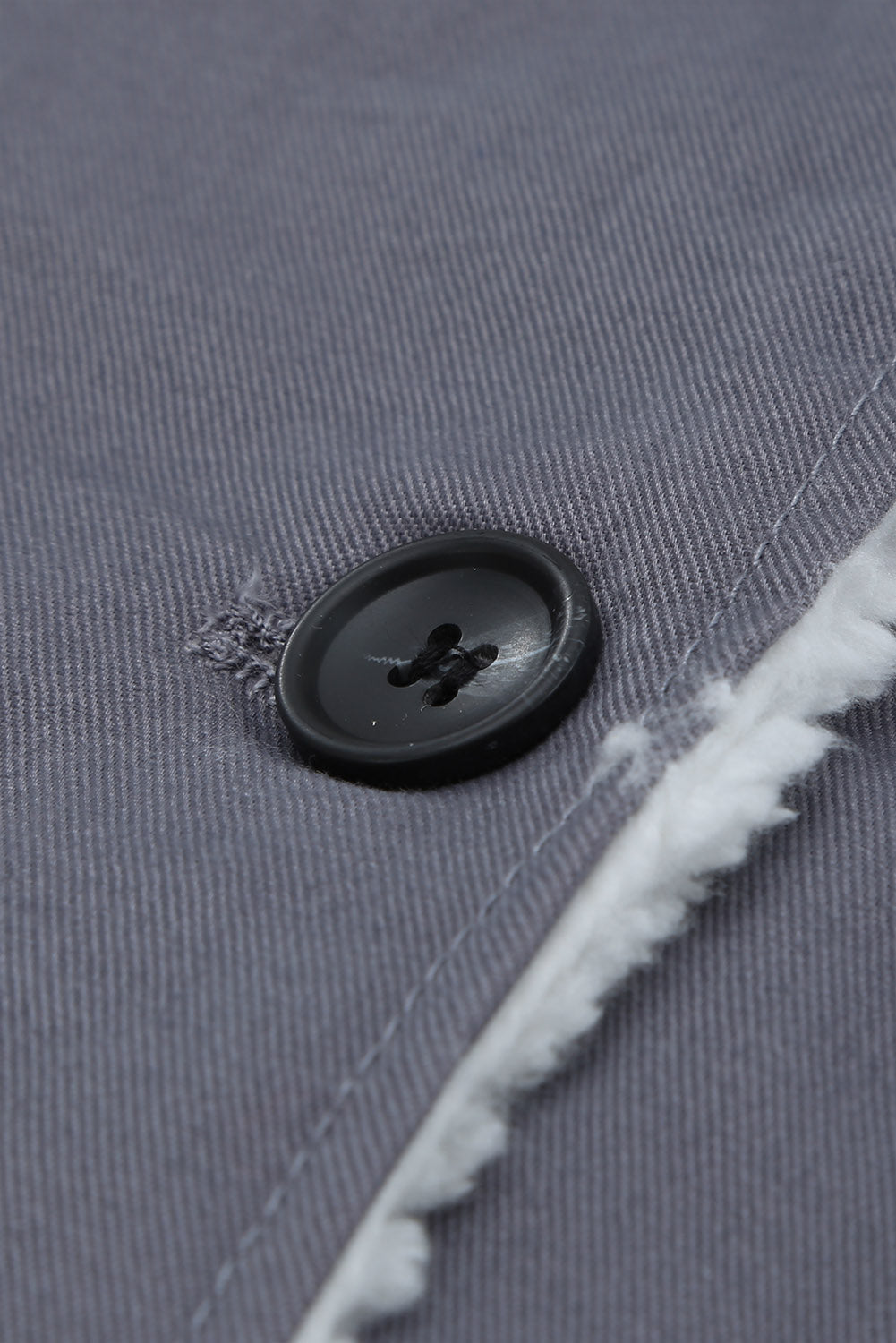 Sherpa-lined canvas button-down jacket in dark gray, showing a black button and fuzzy trim detail.