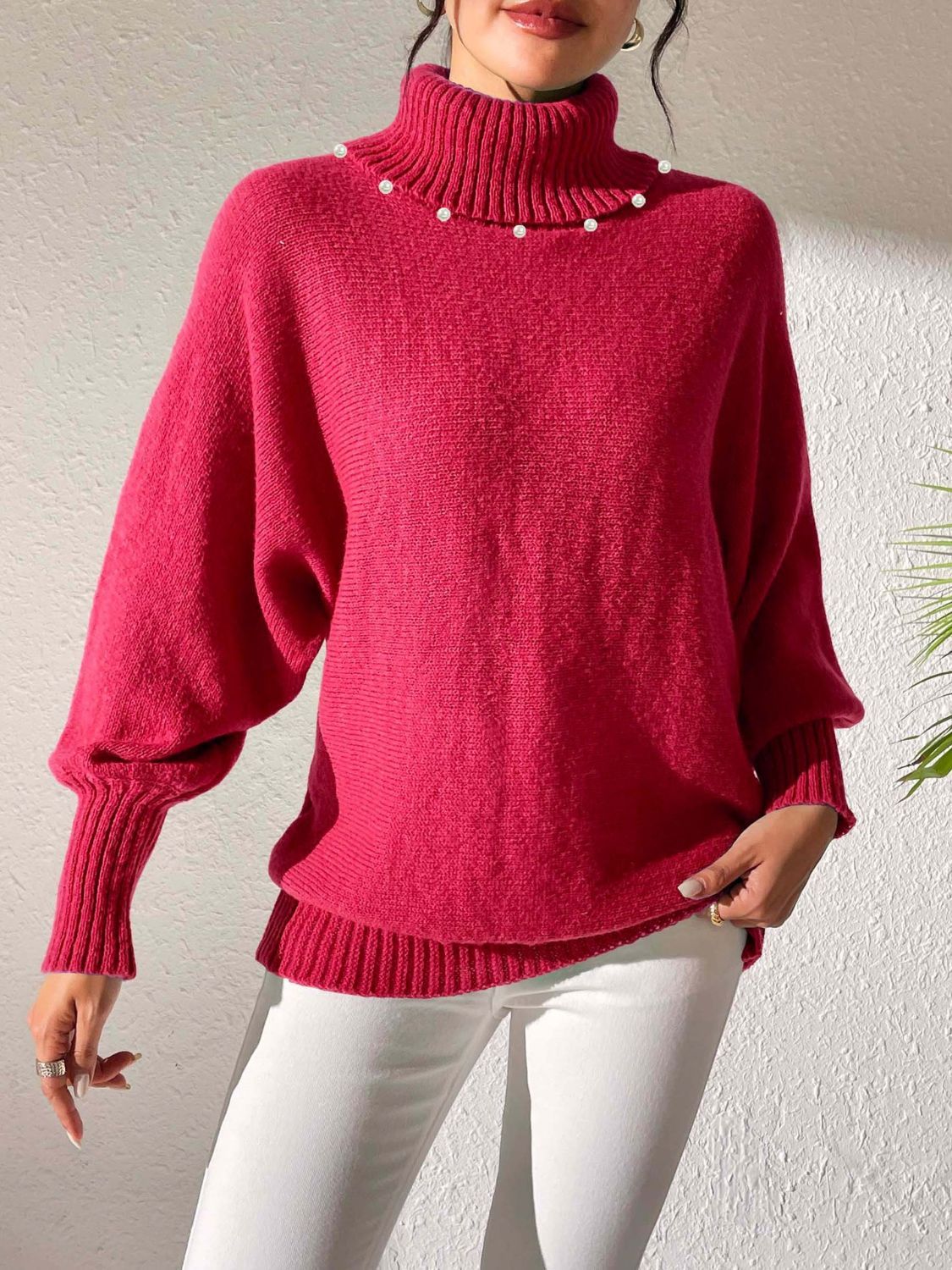 Deep Red knit sweater with pearl-embellished turtleneck and dolman sleeves.