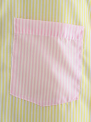 Colorblock oversized button-down shirt with pink and white striped pocket on yellow and white striped fabric.