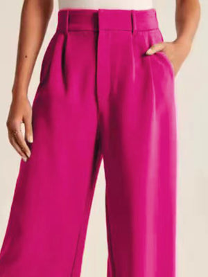 Deep Rose pleated palazzo trousers with a high waist and wide leg, shown with a hand in the pocket.